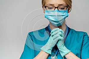 Medical doctor nurse woman wearing protective mask and latex gloves - praying nad hoping gesture