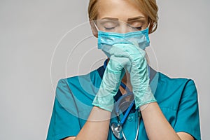 Medical doctor nurse woman wearing protective mask and latex gloves - praying nad hoping gesture