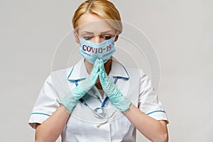 Medical doctor nurse woman wearing protective mask and latex gloves - praying nad hoping gesture