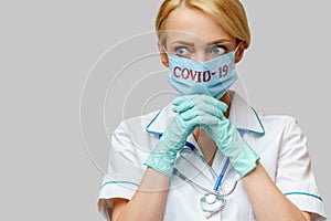 Medical doctor nurse woman wearing protective mask and latex gloves - praying nad hoping gesture