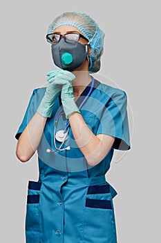 Medical doctor nurse woman wearing protective mask and latex gloves - praying nad hoping gesture