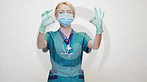 Medical doctor nurse woman wearing protective mask and latex gloves - showing OK sign