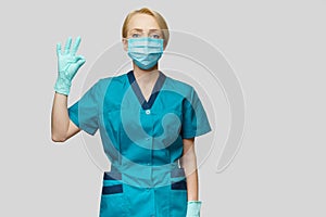 Medical doctor nurse woman wearing protective mask and latex gloves - showing OK sign