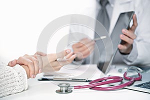 Medical doctor and patient discussing and consulting in hospital examination room photo