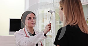 Medical doctor performs a neurological examination using a reflex hammer