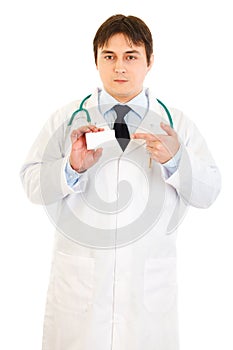Medical doctor pointing on blank business card