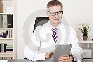 Medical Doctor Reading Reports Using Tablet