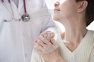 Medical doctor reassuring senior patient and putting a hand on patientâ€™s shoulder