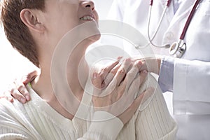 Medical doctor reassuring senior patient and putting a hand on patientâ€™s shoulder