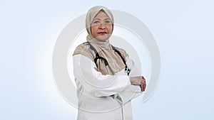 Medical doctor, serious muslim woman and arms crossed in studio for healthcare, medicine or wellness. Hijab, islam and