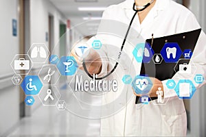 Medical Doctor with stethoscope and Medicare icon in Medical network connection on the virtual screen on hospital background. photo