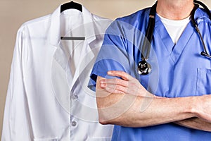 Medical doctor wearing blue scrubs with white consultation coat