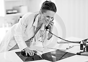 Medical doctor woman with fluorography talking phone in of