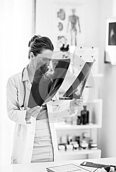 Medical doctor woman looking on fluorography in office