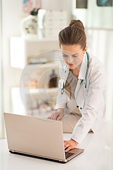 Medical doctor woman working on laptop in office