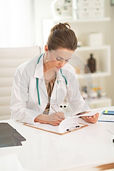 Medical doctor woman writing in clipboard