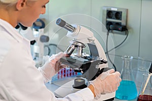 Medical doctor working in research lab. Science assistant making experiments. Laboratory tools: microscope, test tubes