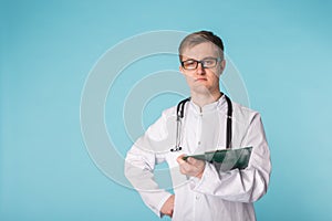 Medical doctor writing prescription over blue background with copy space.