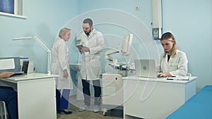 Medical doctors busy working in the office using laptops and tablet