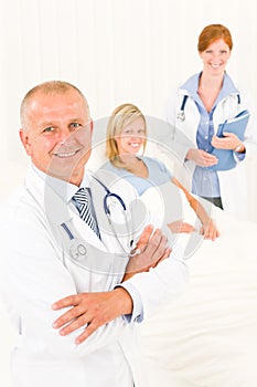 Medical doctors with hospital patient lying bed