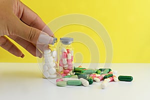 Medical drugs taplets in jars in the hand of a girl holding