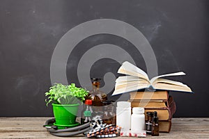 Medical education concept - books, pharmacy bottles, stethoscope in the auditorium with blackboard