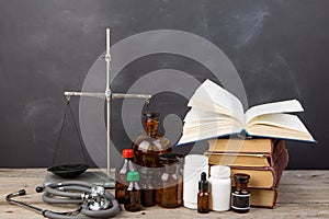 Medical education concept - books, pharmacy bottles, stethoscope in the auditorium with blackboard