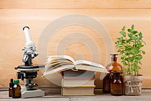 Medical education concept - microscope, books and pharmacy bottles