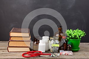 Medical education concept - money glass, books, pharmacy bottles