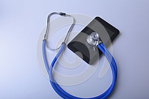Medical equipment: blue stethoscope and tablet on white background