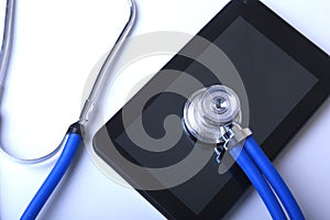 Medical equipment: blue stethoscope and tablet on white background
