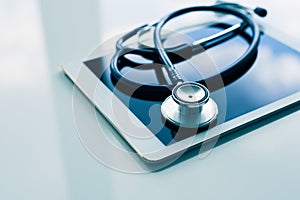 Medical equipment on table. Blue stethoscope and tablet