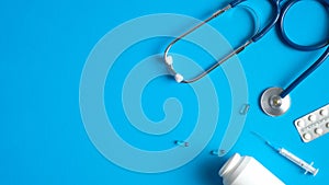 Medical equipment, tools, supplies on blue background. Flat lay stethoscope, syringes, pills. Medical banner design. Healthcare