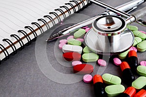 Medical equipments including stethoscope, prescription medicines background, top view flat lay