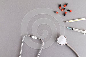 Medical equipments including stethoscope, syringe, drug medicines background, top view flat lay