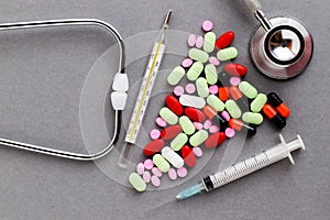 Medical equipments including stethoscope, syringe, drug medicines background, top view flat lay