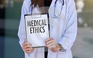 Medical Ethics text with document brown envelope and stethoscope  on office desk