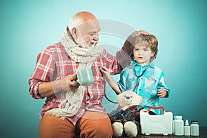 Medical examination boy cute child and his father doctor. Elderly man with little cute doctor. Family playing in doctor