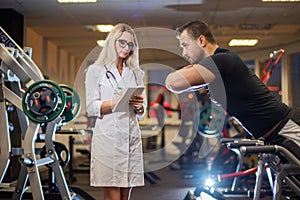 Medical examination. heart rate The doctor measures the pulse during a stress test. A female doctor measures a male