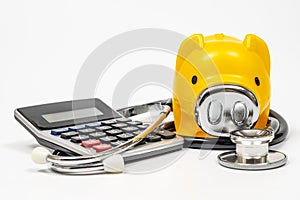 Medical expenses concept with piggy bank, calculator and stethoscope