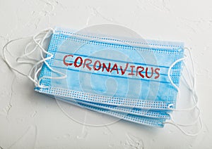 Medical face mask with coronavirus written on it on white background. Best protection from coronavirus, germs,bacteria and viruses