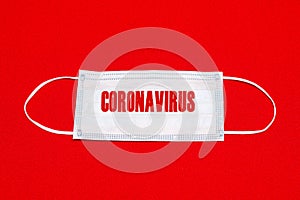 Medical face mask flat lay isolated on red bright background. coronavirus text epidemic concept. safety supplies