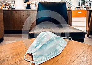 Medical Face Mask for Health care and Virus Protection on Cafe Desk in Coffee Shop. Prevention Disease From Coronavirus Pandemic