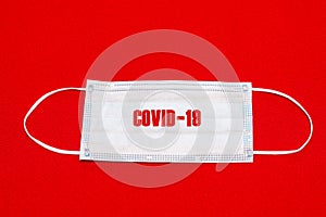 Medical face mask isolated on red bright background. covid-19 text on medical mask coronavirus epidemic concept