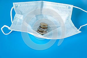 Medical face mask with money on a blue background, business concept for selling masks.