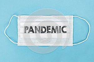Medical face mask with pandemic text on blue background