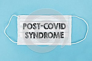 Medical face mask with POST-COVID SYNDROME text on blue background