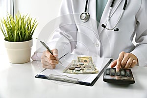 Medical fee, Health insurance, Doctor writing medication note and calculate the examination charges in hospital.