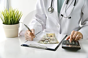 Medical fee, Health insurance, Doctor writing medication note and calculate the examination charges in hospital. photo
