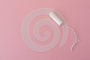 Medical female tampon on a pink background. Hygienic white tampon for women. Cotton swab. Menstruation, protection concept, flat